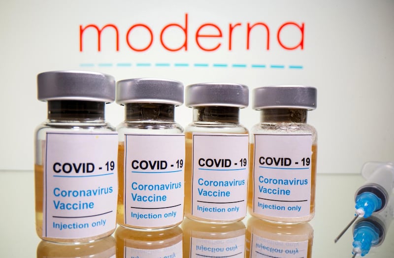 FILE PHOTO: Vials with a sticker reading, "COVID-19 / Coronavirus vaccine / Injection only" and a medical syringe are seen in front of a displayed Moderna logo in this illustration taken October 31, 2020. REUTERS/Dado Ruvic/File Photo