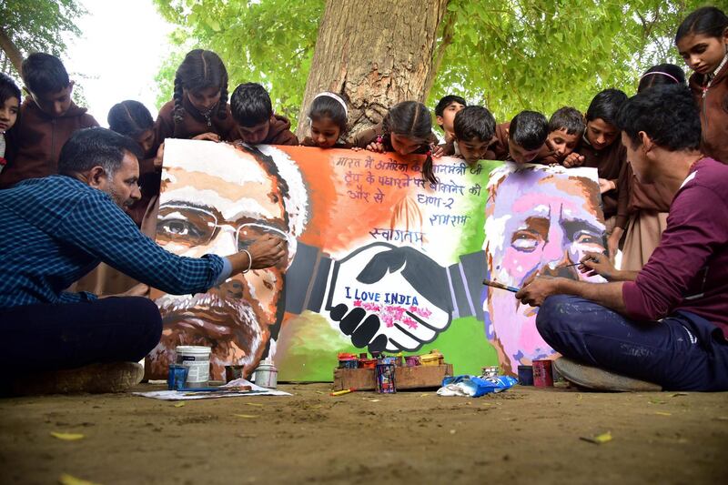 Artists give final touches of a painting depicting US President Donald Trump and India's Prime Minister Narendra Modi in Bikaner, ahead of US President Donald Trump first official visit to India.  AFP