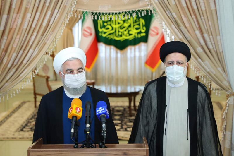 Hassan Rouhani, left, with Ebrahim Raisi, who succeeded Mr Rouhani as Iran's president in August.