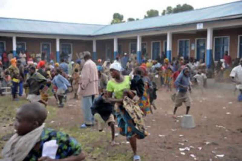 A crowd of refugees are chased away from a help center of the USAID next to a refugee camp in the outskirts of Goma in the North Kivu region of DR Congo on October 31 2008.