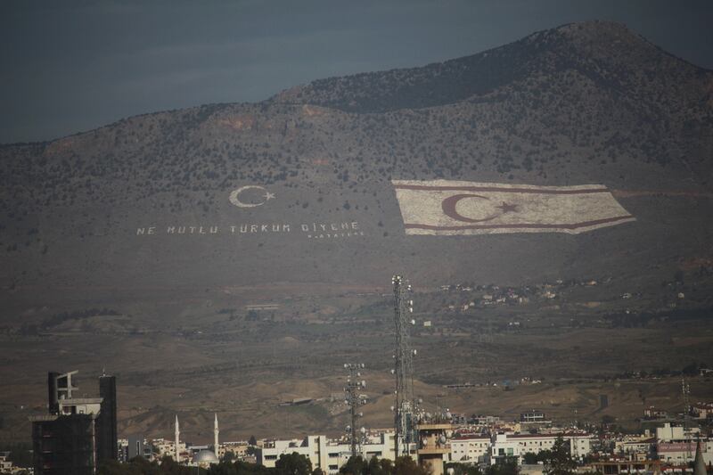 A giant Turkish Cypriot flag embossed on a mountain overlooking Nicosia and southern Cyprus. The words next to it read 'How happy is the one who says "I am a Turk"'. The National