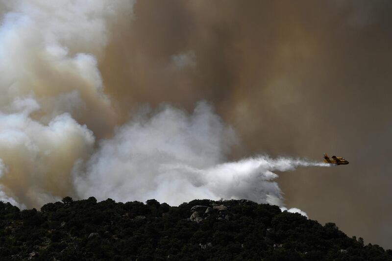A Canadair drops water over a wildfire in the outskirts of Cenicientos in central Spain. Spain was hit by more wildfires as temperatures remained sky-high in the Europe-wide heatwave. AFP