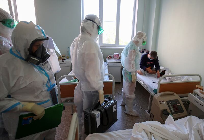Members of a local election commission wearing personal protective equipment (PPE) and carrying a mobile ballot box and documents visit patients suffering from Covid-19 during the Russian parliamentary election at the red zone of a hospital for war and labour veterans in Volgograd, Russia. Reuters