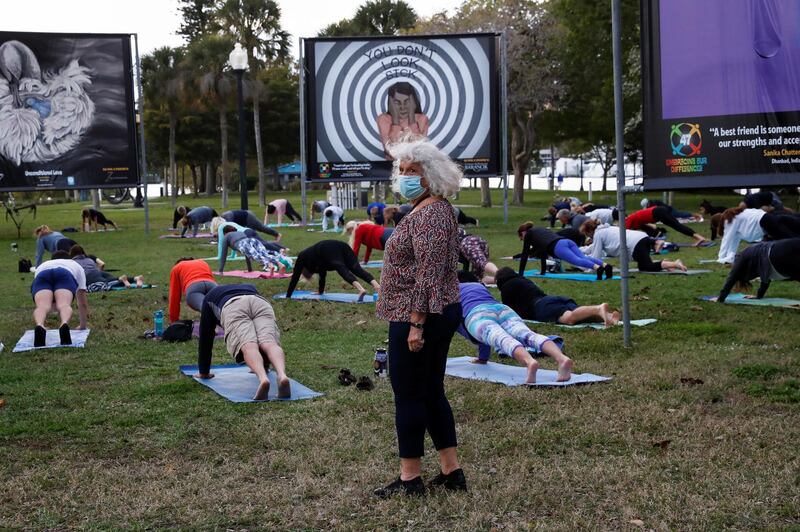 A woman stands while others do yoga at Bayfront Park in Sarasota, Florida. Reuters