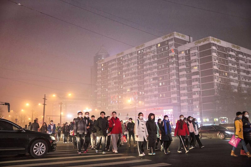 BEIJING, CHINA - DECEMBER 01: Chinese commuters cross a road on a day of high pollution on December 1, 2015 in Beijing, China. China's capital and many cities in the northern part of the country recorded the worst smog of the year with air quality devices in some areas unable to read such high levels of pollutants. Levels of PM 2.5, considered the most hazardous, crossed 600 units in Beijing, nearly 25 times the acceptable standard set by the World Health Organization. The governments of more than 190 countries are meeting in Paris this week to set targets on reducing carbon emissions in an attempt to forge a new global agreement on climate change. (Photo by Kevin Frayer/Getty Images)