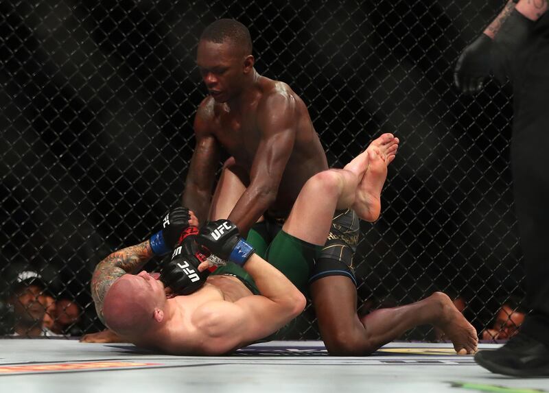 Israel Adesanya pins Marvin Vettori to the mat.