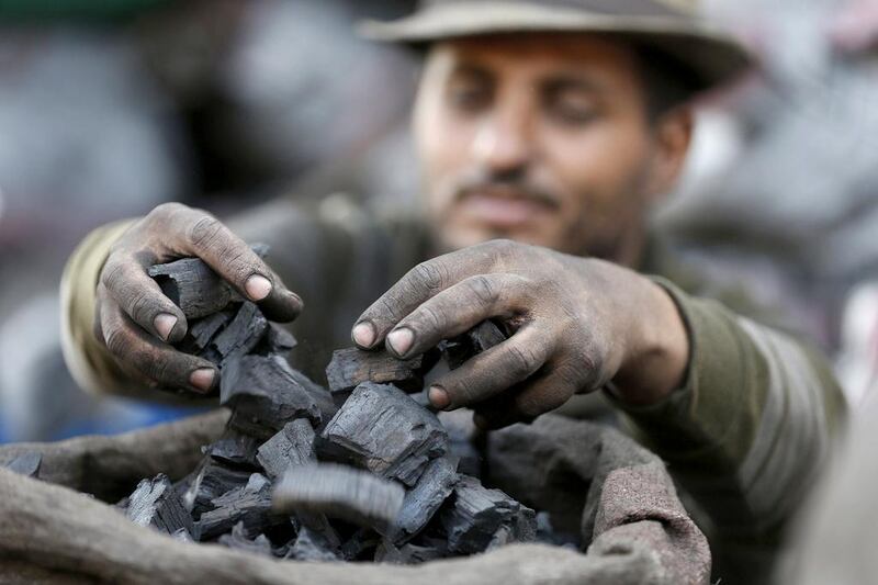 A worker gathers coals in a bag before being sold at one of the charcoal sites in Jeddah, Saudi Arabia. Faisal Al Nasser / Reuters