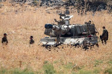 Israeli soldiers stand next to an Israeli mobile artillery unit placed in northern Israel near the border with Lebanon. AP