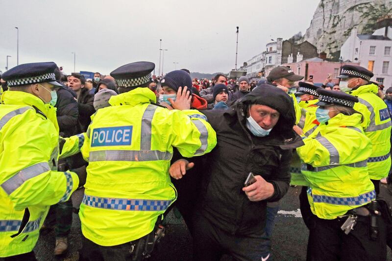 Truck drivers argue with police holding them back at the entrance to the Port of Dover, in Kent, England, Wednesday Dec. 23, 2020. Freight from Britain and passengers with a negative virus test began arriving on French shores Wednesday, after France relaxed a two-day blockade over a new virus variant that had isolated Britain, stranded thousands of drivers and raised fears of shortages. (Steve Parsons/PA via AP)