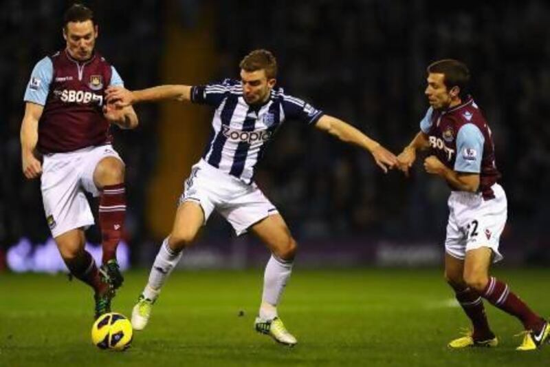 James Morrison, centre, the West Bromwich Albion midfielder, tries to fend off the challenge of two West Ham players. Laurence Griffiths / Getty Images