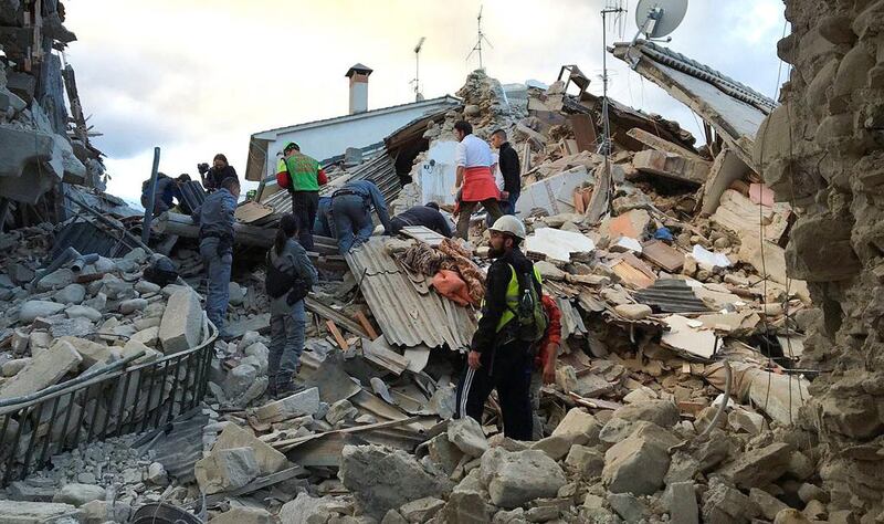 Rescuers work at a collapsed house following a quake in Amatrice, central Italy. Emiliano Grillotti / Reuters
