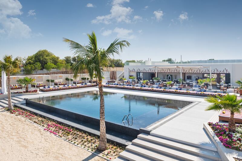 The temperature-controlled swimming pool surrounded by loungers.