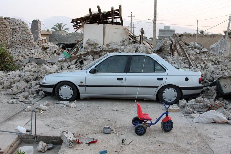 epa03655898 A car is buried under the rubble after an earthquake in the Shonbeh Twon in Bushehr province in southern Iran, 09 April 2013. The quakes, ranging in magnitude 6.3 on the Richter Scale, shook the Shanbeh town and other communities in Bushehr province in southern Iran on 09 April 2013. At least 37 people were killed in a 6.3-magnitude earthquake near Bushehr in southern Iran, state television reported.  EPA/MOHAMAD FATEMI *** Local Caption ***  03655898.jpg