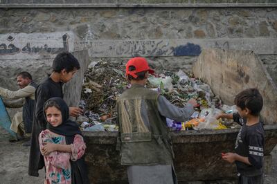 Children collect food and recyclable materials from waste near the airport in Kabul. AFP 