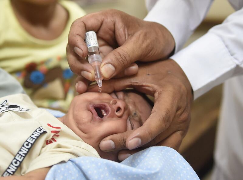 A Pakistani health worker administers polio drops to a child during a polio vaccination campaign in Karachi on June 17, 2019. (Photo by RIZWAN TABASSUM / AFP)