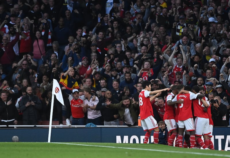 Arsenal's Bukayo Saka celebrates with teammates after scoring the winner. EPA