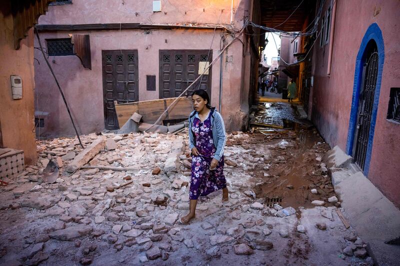 A woman walks through rubble in the old city of Marrakesh on September 9. AFP