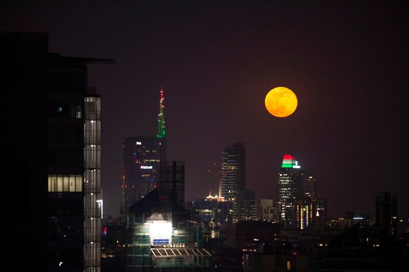 The supermoon passes in the night sky behind the high-rise buildings in Milan, Italy.  EPA