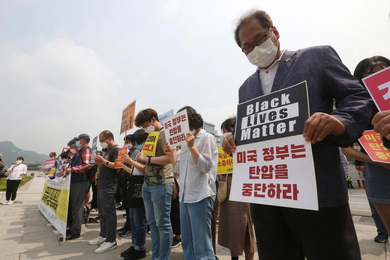 South Korean protesters take a moment of silence during a protest over the death of George Floyd near the US embassy in Seoul. AP Photo