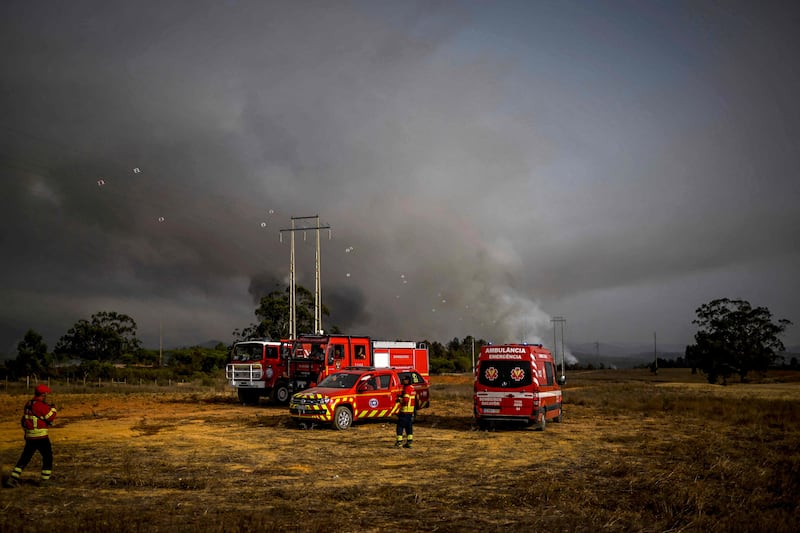 Firefighters watch the progression of a wildfire near Odeceixe village, Portugal. AFP