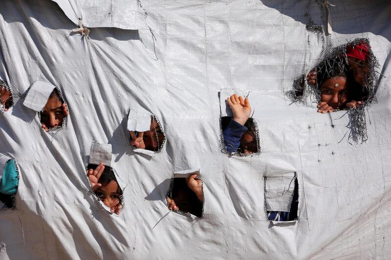 Children look through holes in a tent at Al Hol displacement camp in Hasaka governorate, Syria. Reuters