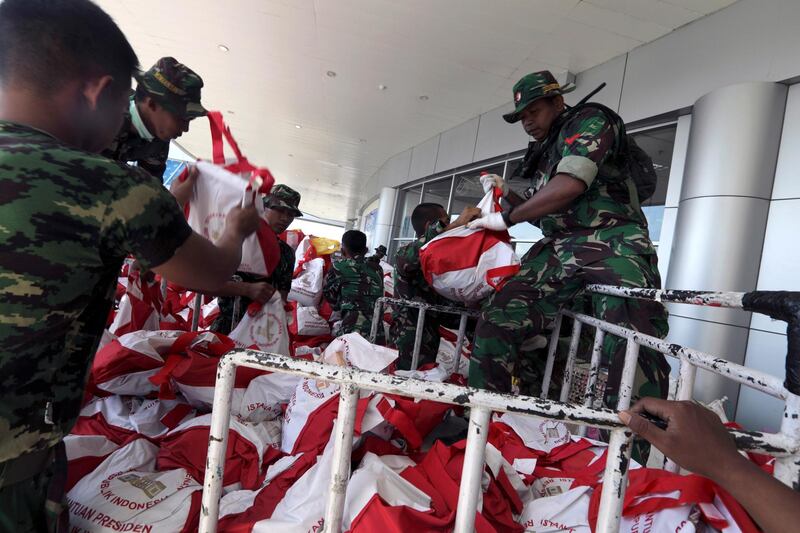 Military personnel unload humanitarian aid and disaster relief supplies at Mutiara Al Jufri Airport in Palu. EPA