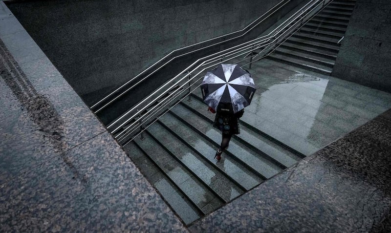 A woman with an umbrella walks out of an underground crossing in Moscow, Russia. Yuri Kadobnov / AFP