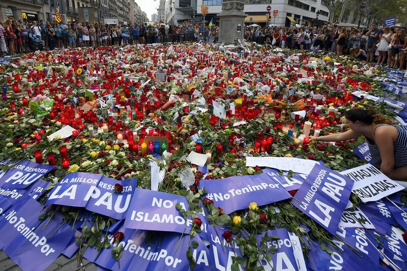 People place placards and candles to pay tribute to the victims of the Barcelona and Cambrils attacks on the Rambla boulevard in Barcelona on August 26, during a march against terrorism which slogan is #NoTincPor (I'm Not Afraid).
Tens of thousands of Spaniards and foreigners staged a defiant march against terror through Barcelona on August 26 following last week's deadly vehicle rampages. The Mediterranean city is in mourning after a van ploughed into crowds on Las Ramblas boulevard on August 17, followed hours later by a car attack in the seaside town of Cambrils.
 / AFP PHOTO / LLUIS GENE