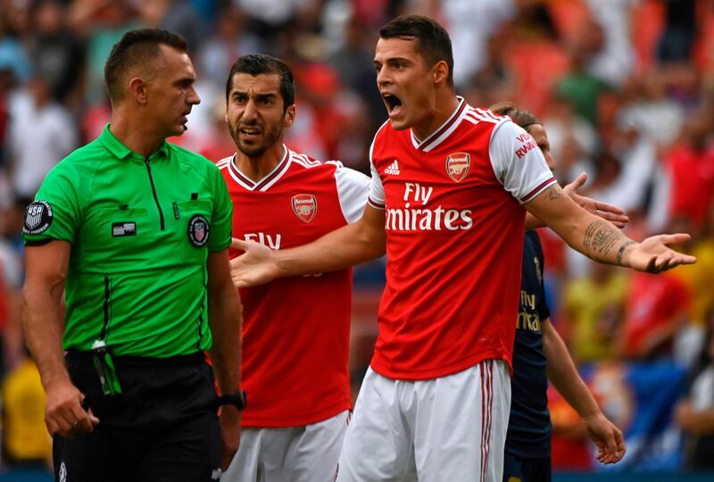 Arsenal players protest to the referee over a decision. EPA