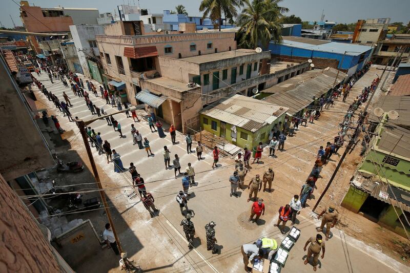 People stand on the lines drawn to maintain safe distance as they wait to receive free food being distributed by Central Reserve Police Force (CRPF) during a 21-day nationwide lockdown to slow the spreading of coronavirus disease (COVID-19) in Chennai, India, April 1, 2020. REUTERS/P. Ravikumar     TPX IMAGES OF THE DAY