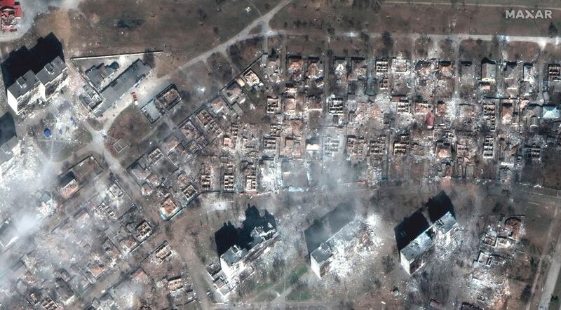 This satellite image provided by Maxar Technologies shows damaged apartment buildings and homes in Mariupol. AP