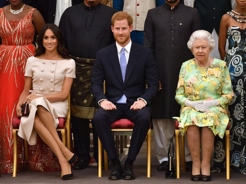 (FILES) In this file photo taken on June 26, 2018 (L-R) Meghan, Duchess of Sussex, Britain's Prince Harry, Duke of Sussex and Britain's Queen Elizabeth II pose for a picture during the Queen's Young Leaders Awards Ceremony at Buckingham Palace in London. 
   Queen Elizabeth II is saddened by the challenges faced by her grandson Prince Harry and his wife Meghan, and takes their allegations of racism in the royal family seriously, Buckingham Palace said on March 9, 2021. "The whole family is saddened to learn the full extent of how challenging the last few years have been for Harry and Meghan. The issues raised, particularly that of race, are concerning," the palace said in a statement released on the queen's behalf. / AFP / POOL / John Stillwell
