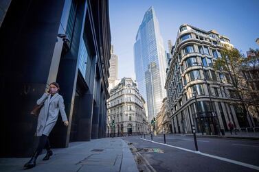 A woman wearing a protective face walks along a quiet street in the City of London. UK economic output is expected to rebound by 17.5% quarter-on-quarter in the three months ended September 30, according to the Institute of Fiscal Studies, but the Bank of England is less optimistic. AFP