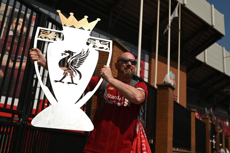 Liverpool fan Paul Davies poses with a cut out trophy outside Anfield stadium in Liverpool. AFP