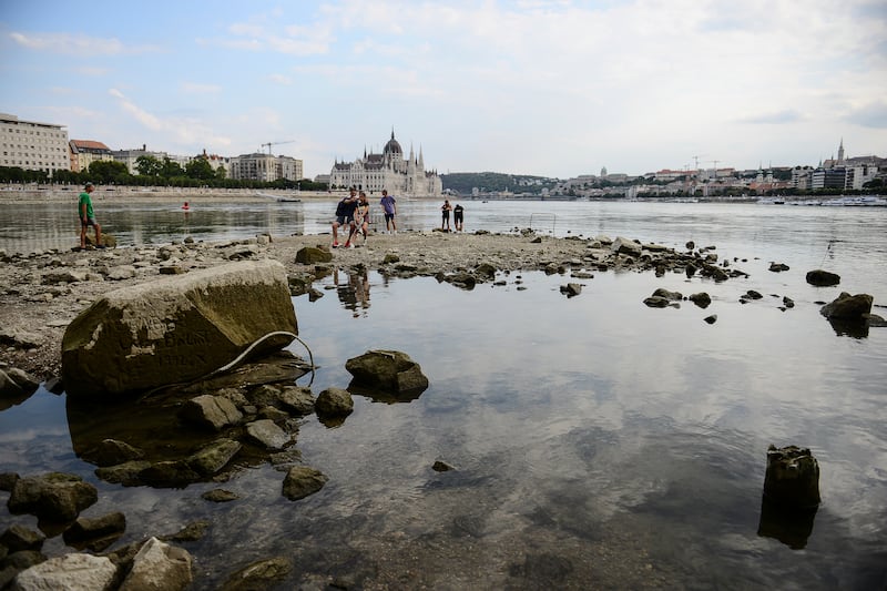 People take photos on the southern tip of Margaret Island, which can be seen due to low water level of the River Danube,  in Budapest, Hungary. AP