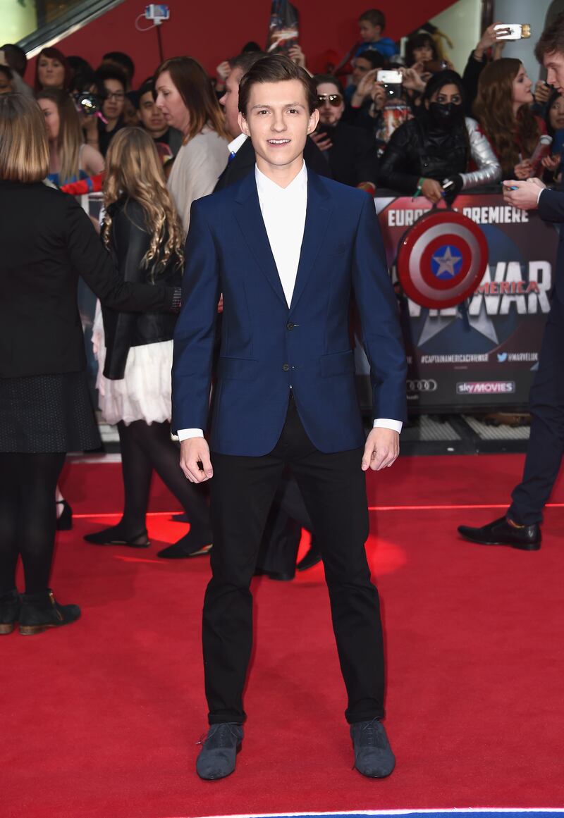 Tom Holland, in a navy suit and white shirt, arrives for UK premiere of 'Captain America: Civil War' in London on April 26, 2016. Getty Images