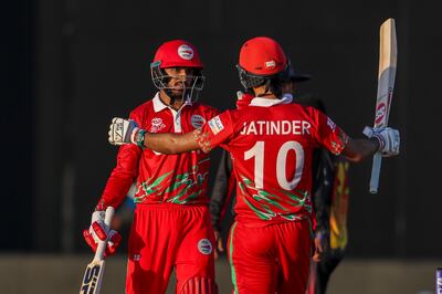 Oman's Aqib Ilyas, left, and teammate Jatinder Singh celebrate after defeating Papua New Guinea by 10 wickets in their T20 World Cup first-round match in Muscat on October 17, 2021. AP