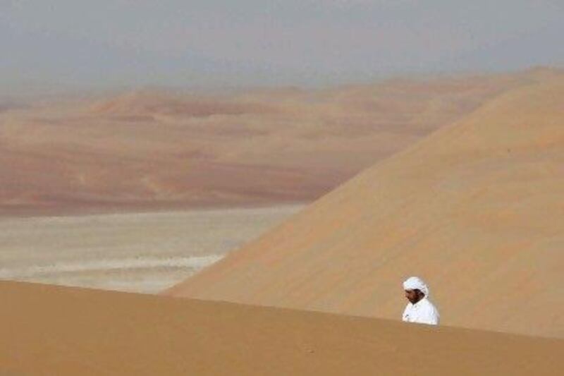 Mubarak Al Mazrouei walks across a sand dune in the Liwa region of the UAE. Andre Forget / The National