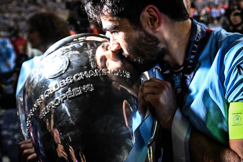 Manchester City's German midfielder #8 Ilkay Gundogan kisses the European Cup trophy as they celebrate winning the UEFA Champions League final football match between Inter Milan and Manchester City at the Ataturk Olympic Stadium in Istanbul. AFP