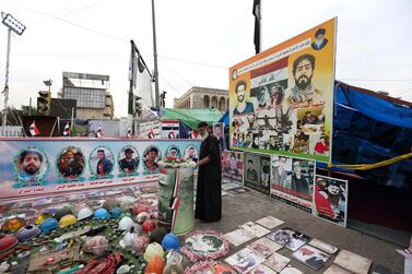 An Iraqi man mourns next to the pictures of protesters, who were killed in clashes with security forces, during the ongoing protests at the Al Tahrir square at the first day of Eid Al Fitr in central Baghdad , Iraq, 24 May 2020. EPA