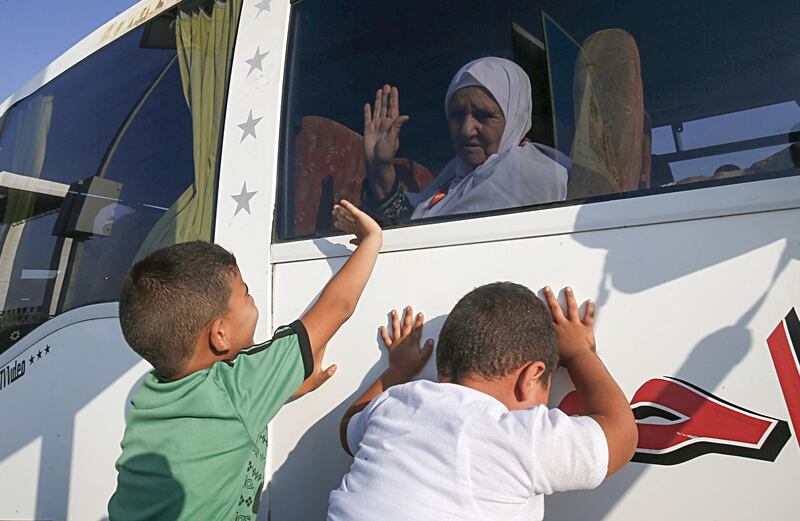 Two young boys wave to an elderly relative.  AFP
