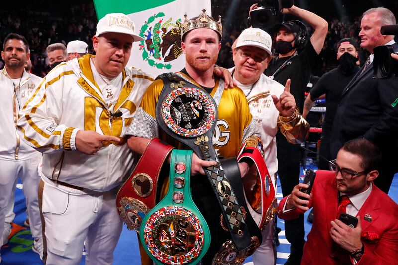 Canelo Alvarez, of Mexico, poses with the WBC, WBA, WBO and IBF belts after defeating Caleb Plant in a super middleweight title unification fight Saturday, November 6, 2021, in Las Vegas.  AP Photo