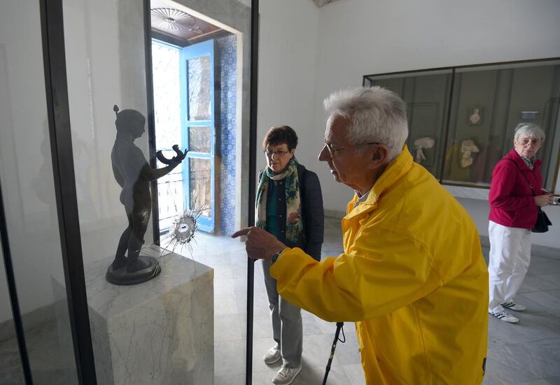 A tourist looks at a bullet hole in a sculpture casing at the Bardo National Museum in Tunis. Visitor numbers to the country have slumped since the attack on March 18 last year. Fethi Belaid / AFP.