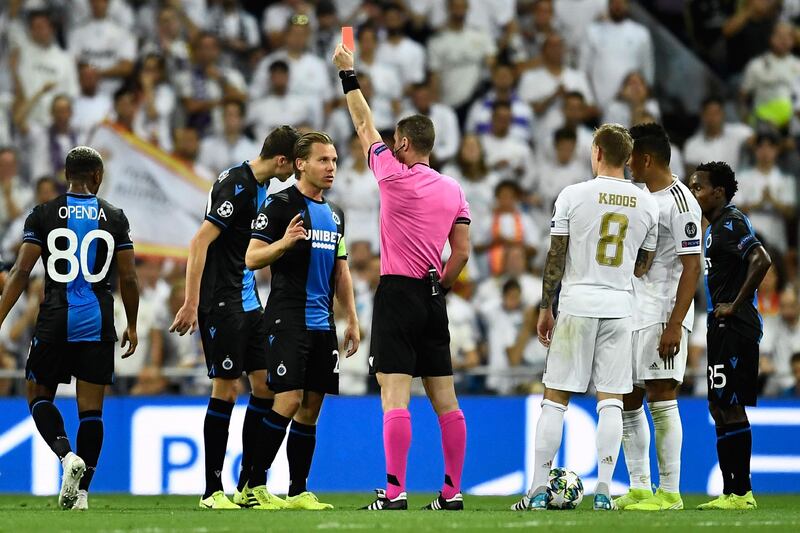 Bulgarian referee Georgi Kabakov shows a red card to Club Brugge's Dutch midfielder Ruud Vormer during the UEFA Champions league Group A football match between Real Madrid and Club Brugge at the Santiago Bernabeu stadium in Madrid.   AFP