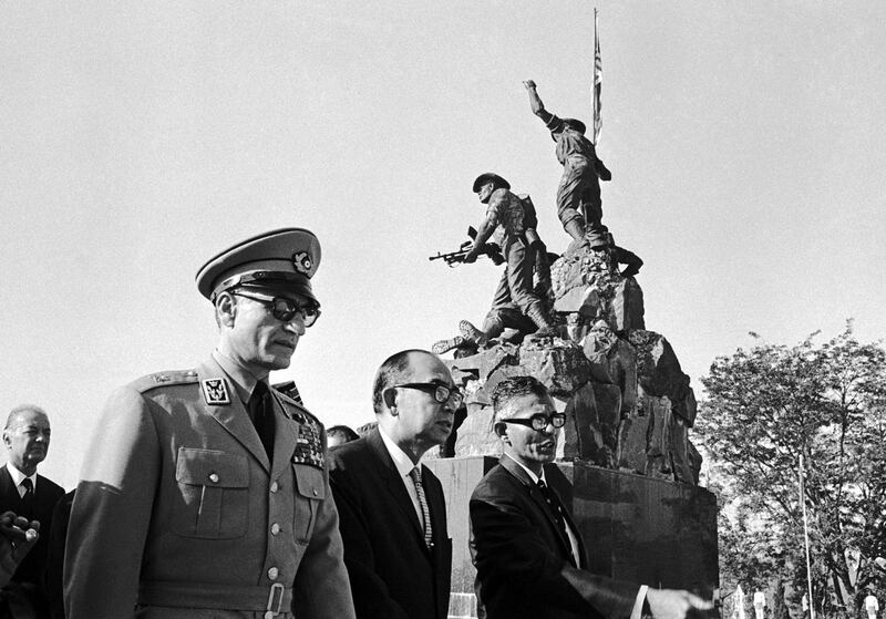 Shah Mohammed Reza Pahlevi of Iran, left, walks with the Deputy Prime Minister of Malaysia Tun Abdul Razak, centre, and an unidentified man past the National Monument in Kula Lumpur, Malaysia, Jan. 18, 1968, after laying a wreath at the War Memorial.  (AP Photo)