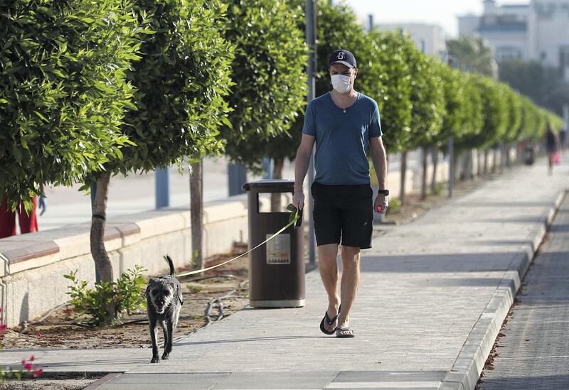 Dubai, United Arab Emirates - Reporter: N/A: Coronavirus. A man walks his dog by the beach on the first morning where the government has eased restrictions on personal travel due to Covid-19. Friday, April 24th, 2020. Dubai. Chris Whiteoak / The National