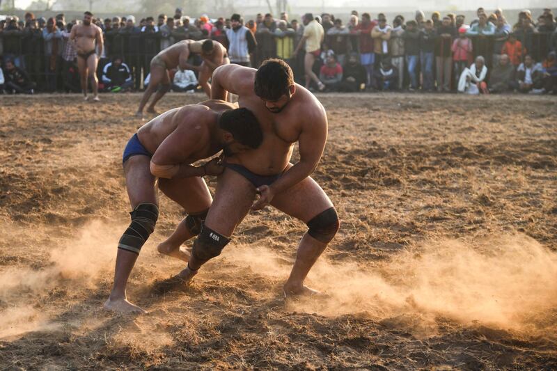 Participants compete in a bout of traditional mud wrestling on Makar Sankranti, on the outskirts of Chandigarh. AFP