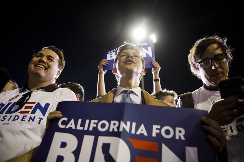 Attendees hold signs during a primary night rally for former Vice President Joe Biden, 2020 Democratic presidential candidate, in the Baldwin Hills neighborhood of Los Angeles, California, U.S. Bloomberg