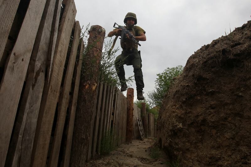 A member of the Ukrainian National Guard jumps into a trench at a position near a front line, as Russia's attack on Ukraine continues, in Kharkiv region, Ukraine. Reuters