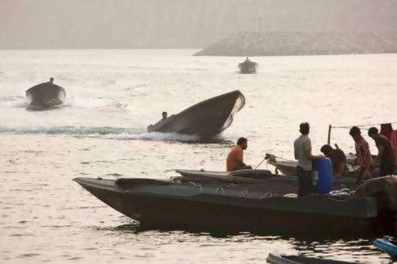 Speedboats are seen arriving at the port of Khasab, in Oman's isolated northern peninsula of Musandam May 1, 2008. Trade with Iran is as ancient as the settlements overlooking the Strait of Hormuz, gateway for a third of the world's oil shipments. In 2005, Iran's police chief said some $6 billion worth of goods were smuggled into the country each year from the Gulf. Smugglers at Musandam say they sometimes bring in fuel, prawns or livestock from Iran, but the trade mostly highlights the way consumer goods, especially U.S. embargoed products like computers, enter the Islamic Republic via Gulf states. Picture taken May 1, 2008. To match feature OMAN-IRAN/SMUGGLING.     REUTERS/Ahmed Jadallah (OMAN)